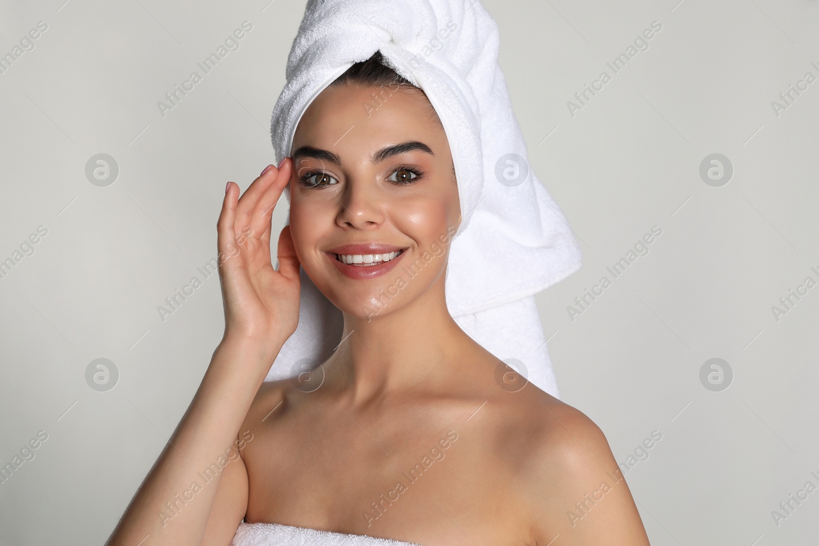 Photo of Beautiful young woman with towels on light background