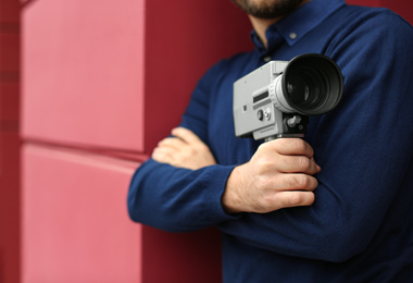 Photo of Man with vintage video camera outdoors, closeup