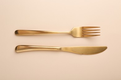 Photo of Stylish cutlery on beige table, top view