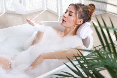 Beautiful woman enjoying bubble bath at home