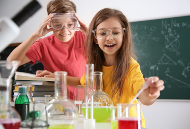 Photo of Smart pupils making experiment in chemistry class