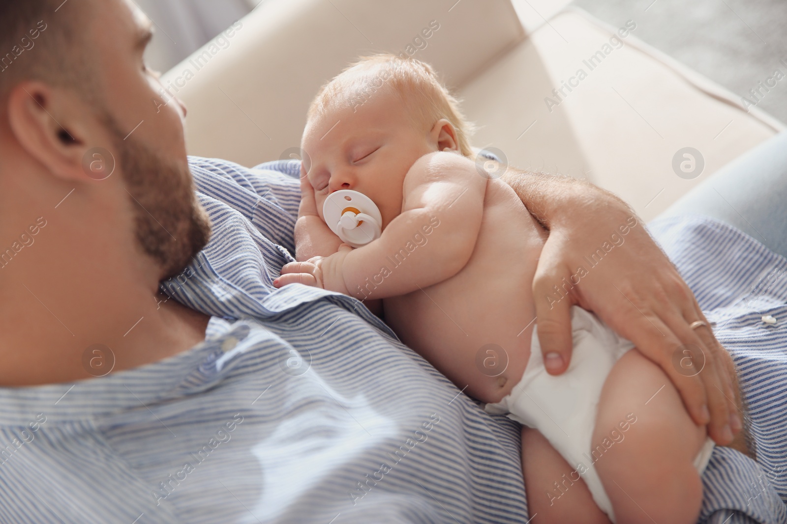 Photo of Father with his newborn son at home, closeup