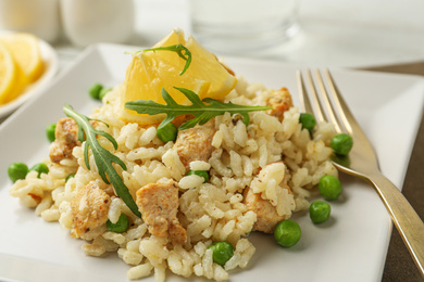 Photo of Delicious chicken risotto with lemon on table, closeup