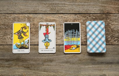 Photo of Tarot cards on wooden table, flat lay