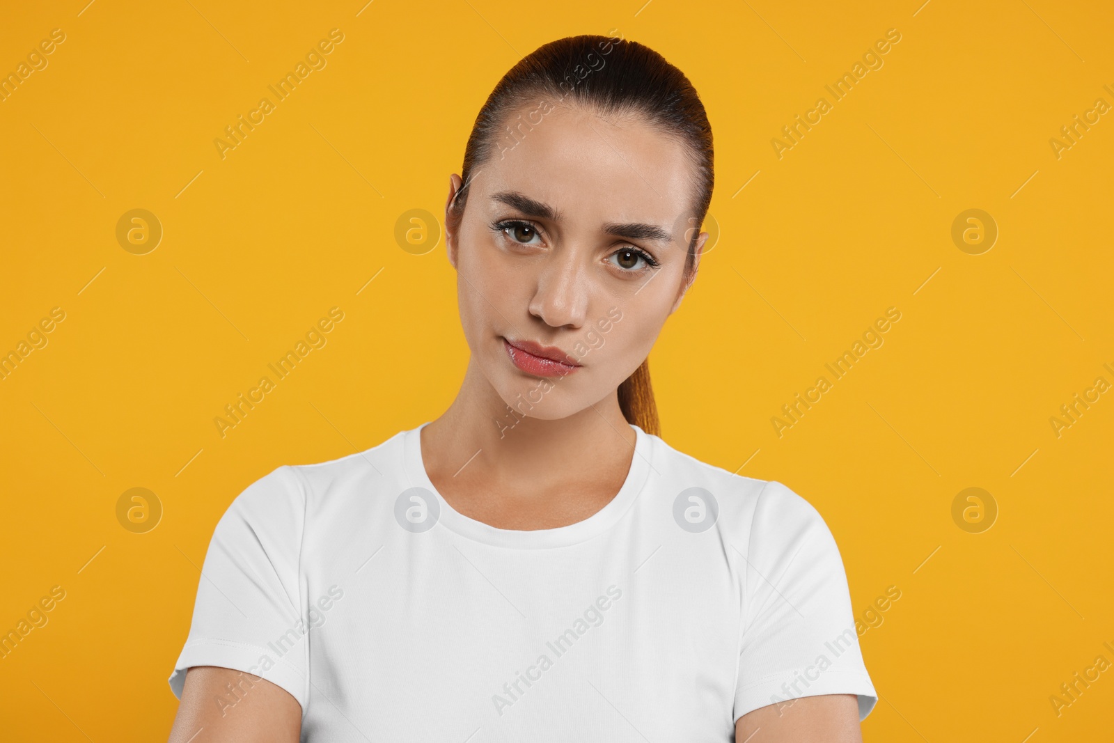 Photo of Portrait of resentful woman on orange background