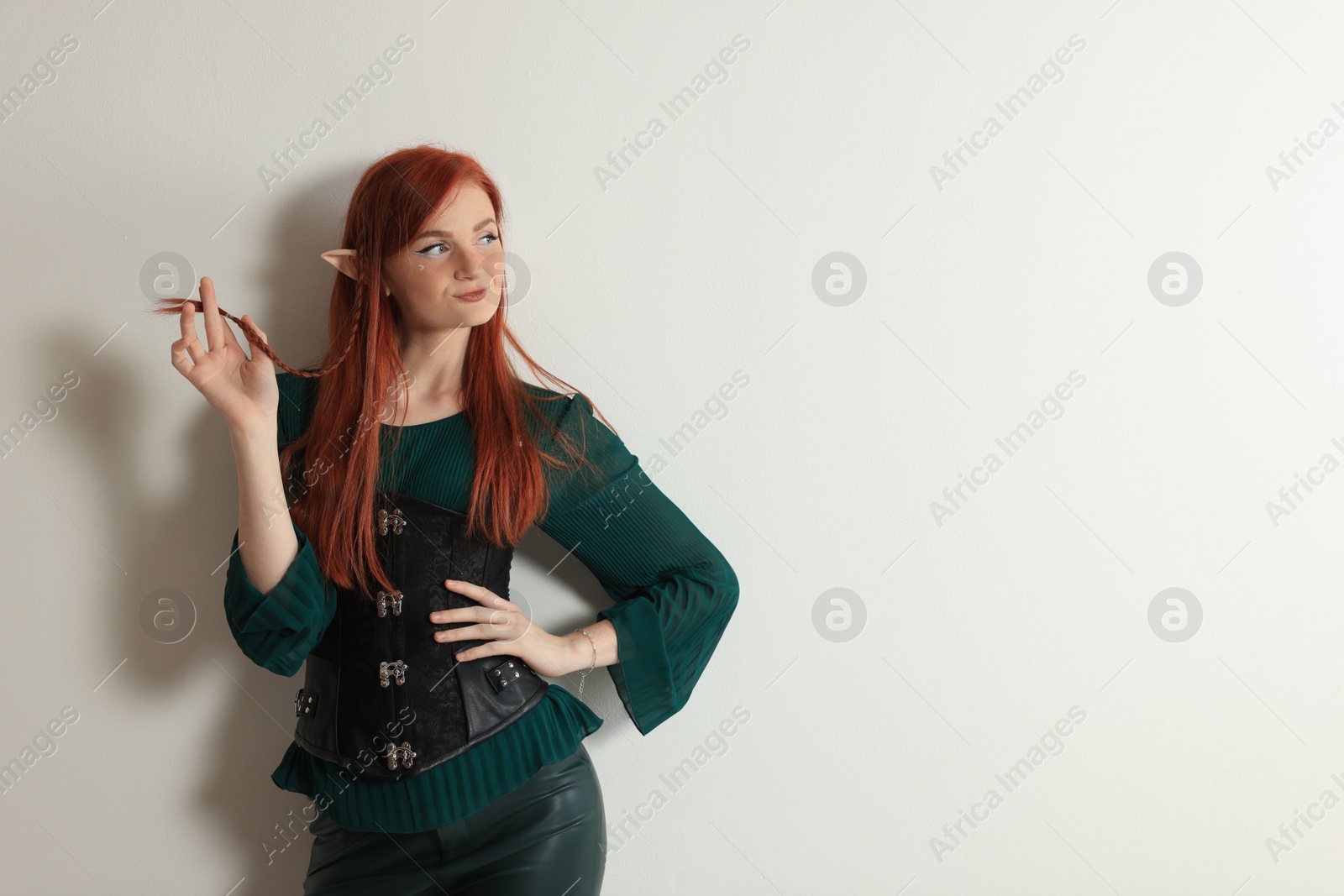 Photo of Beautiful redhead elf girl on light background. Space for text