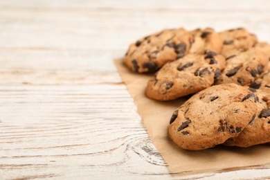 Photo of Tasty cookies with chocolate chips on wooden background, closeup