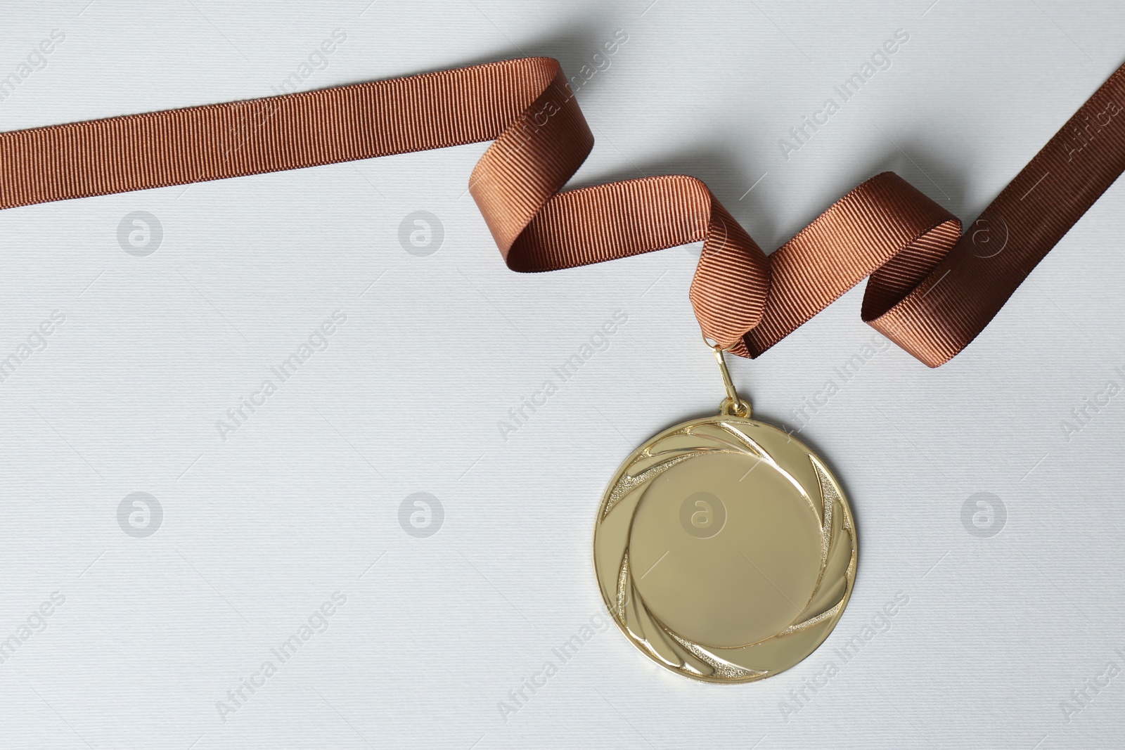 Photo of Gold medal on white background, top view. Space for design