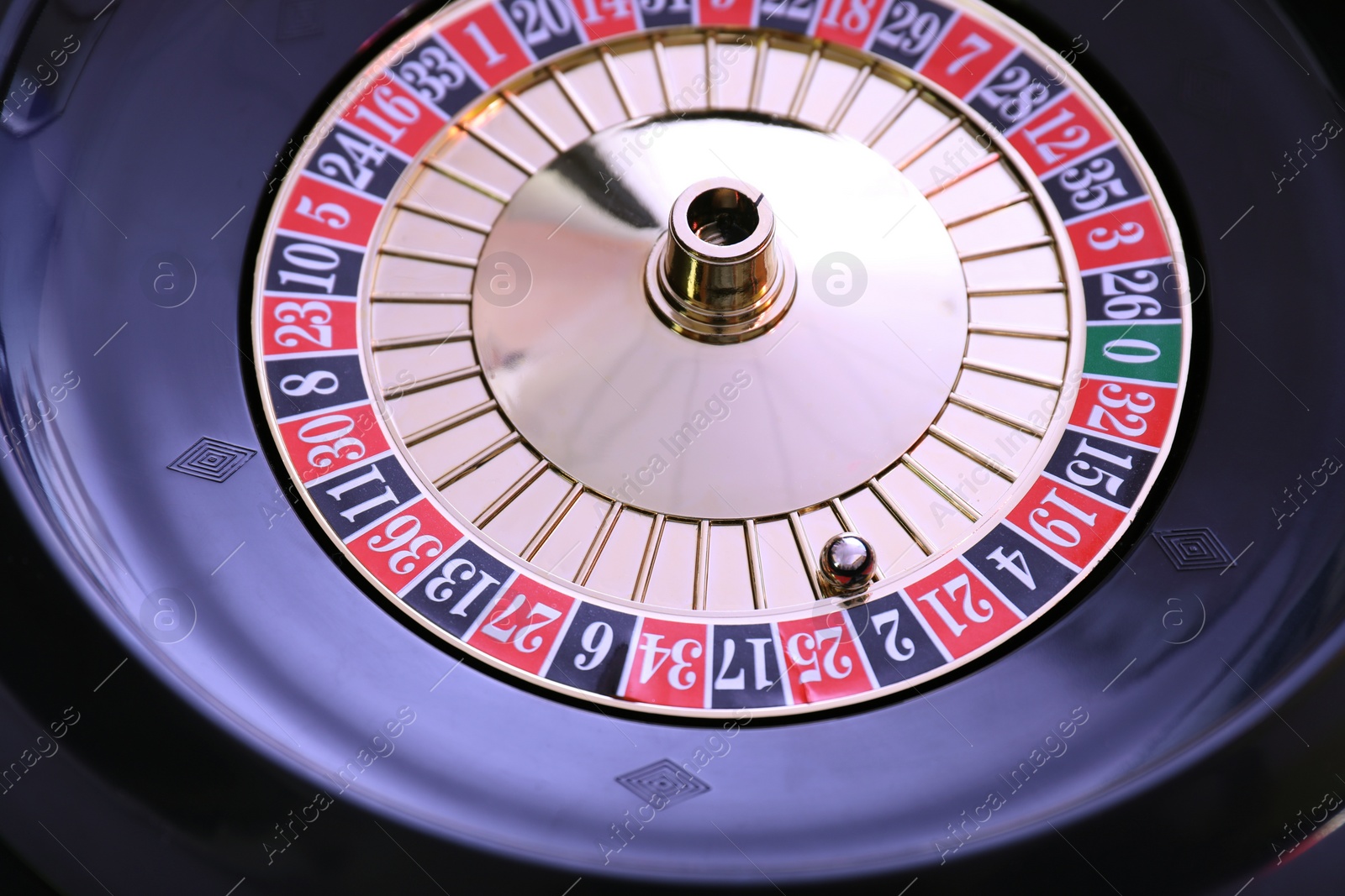 Photo of Roulette wheel with ball, closeup. Casino game