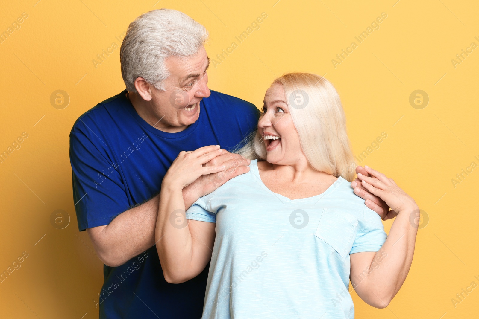 Photo of Adorable mature couple having fun against color background