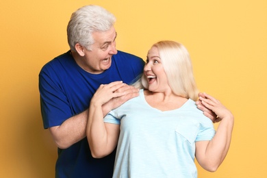 Photo of Adorable mature couple having fun against color background