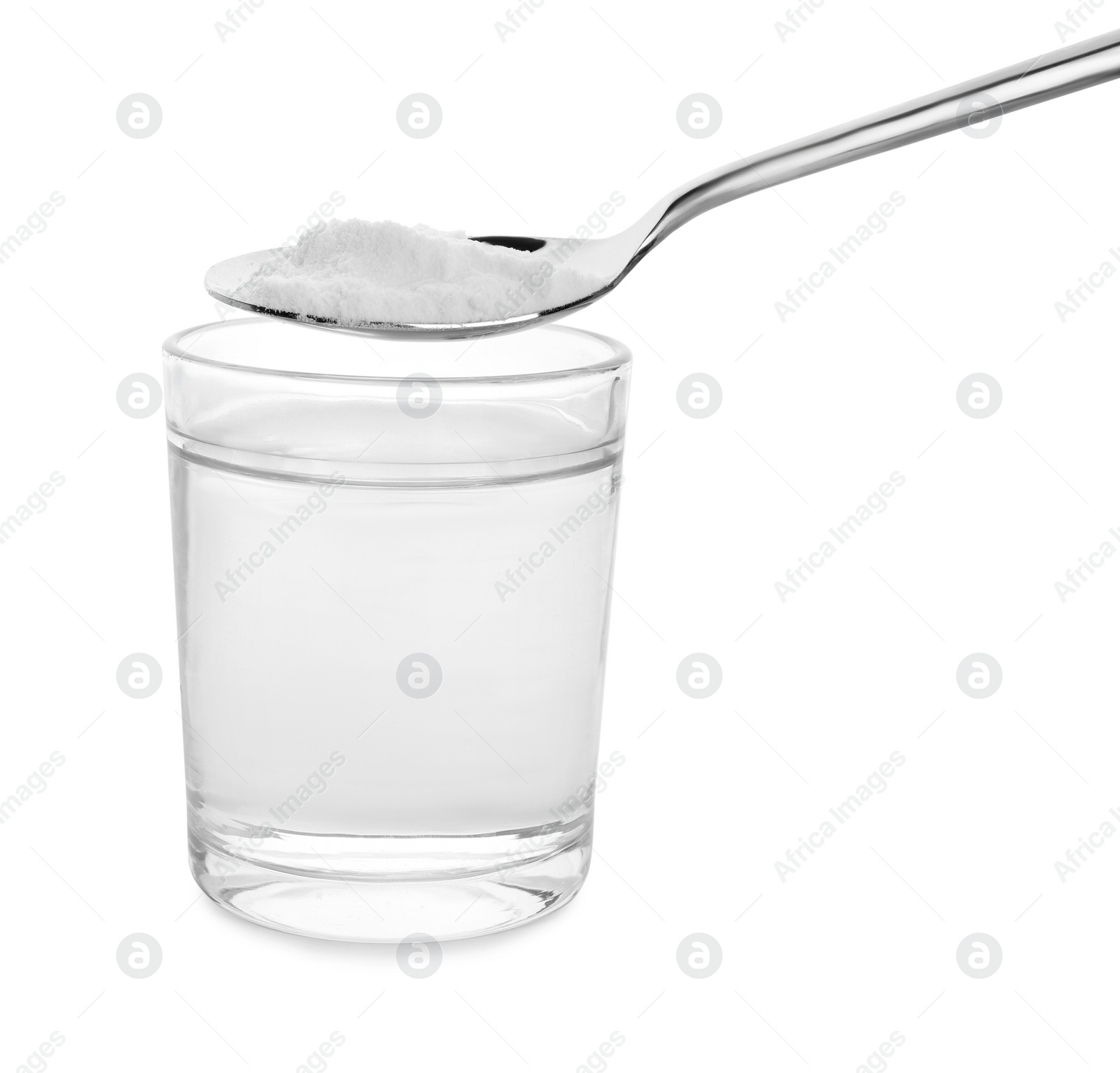 Photo of Spoon with baking soda over glass of water on white background