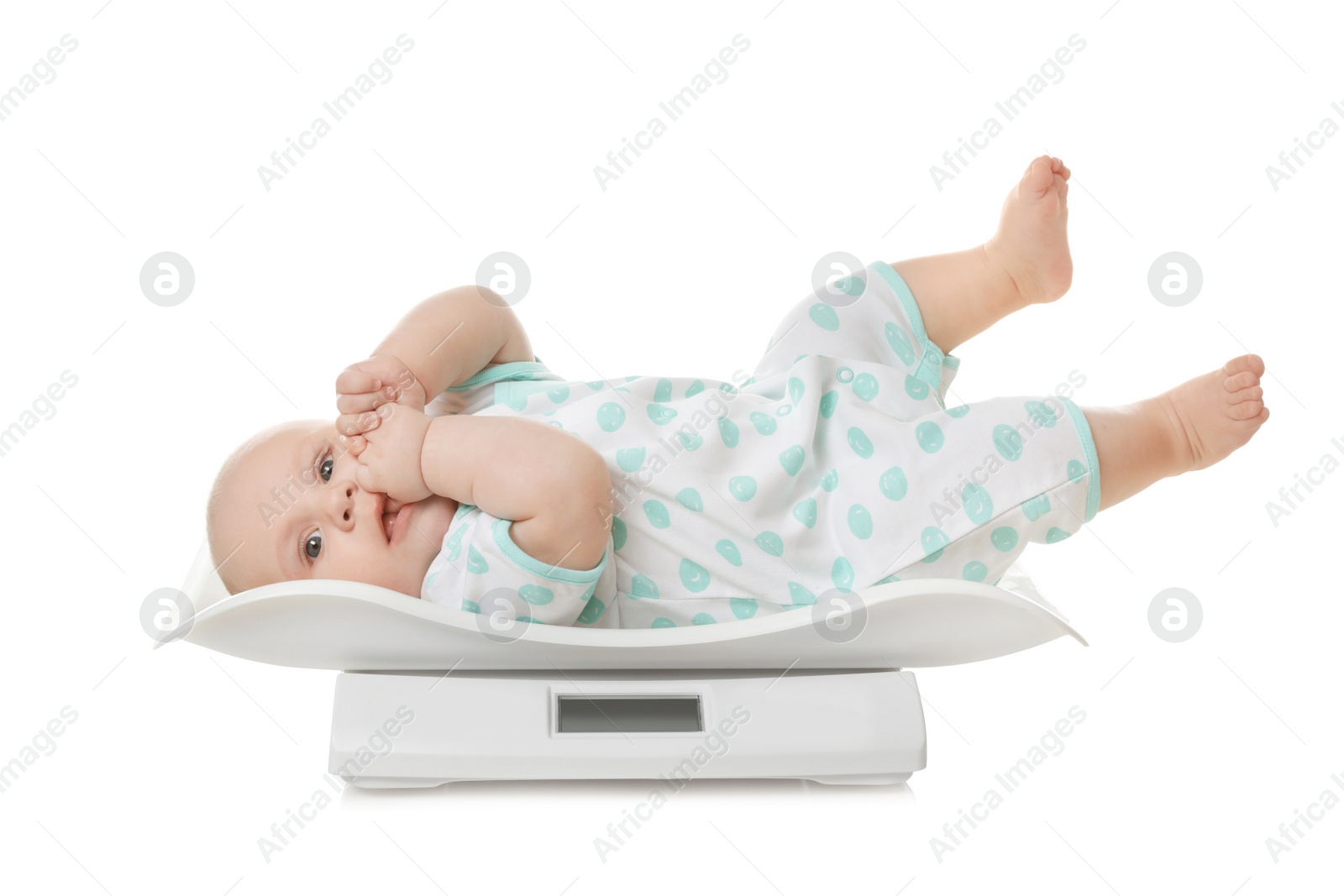 Photo of Cute little baby lying on scales against white background