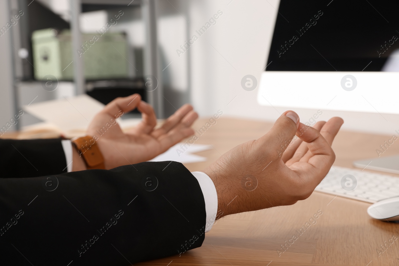 Photo of Businessman meditating at workplace, closeup. Zen concept