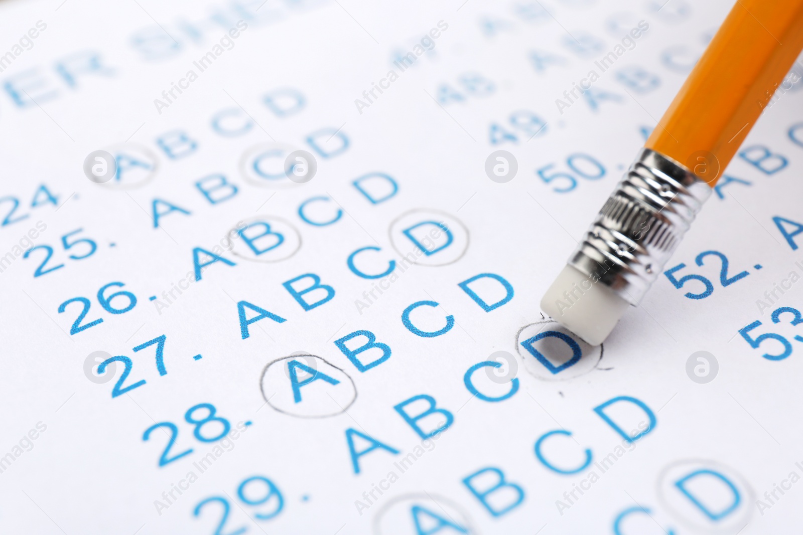 Photo of Correcting mistake with pencil eraser in answer sheet, closeup