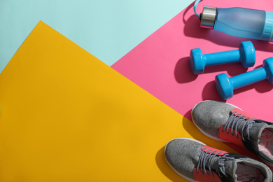 Flat lay composition with fitness equipment on color background, space for text