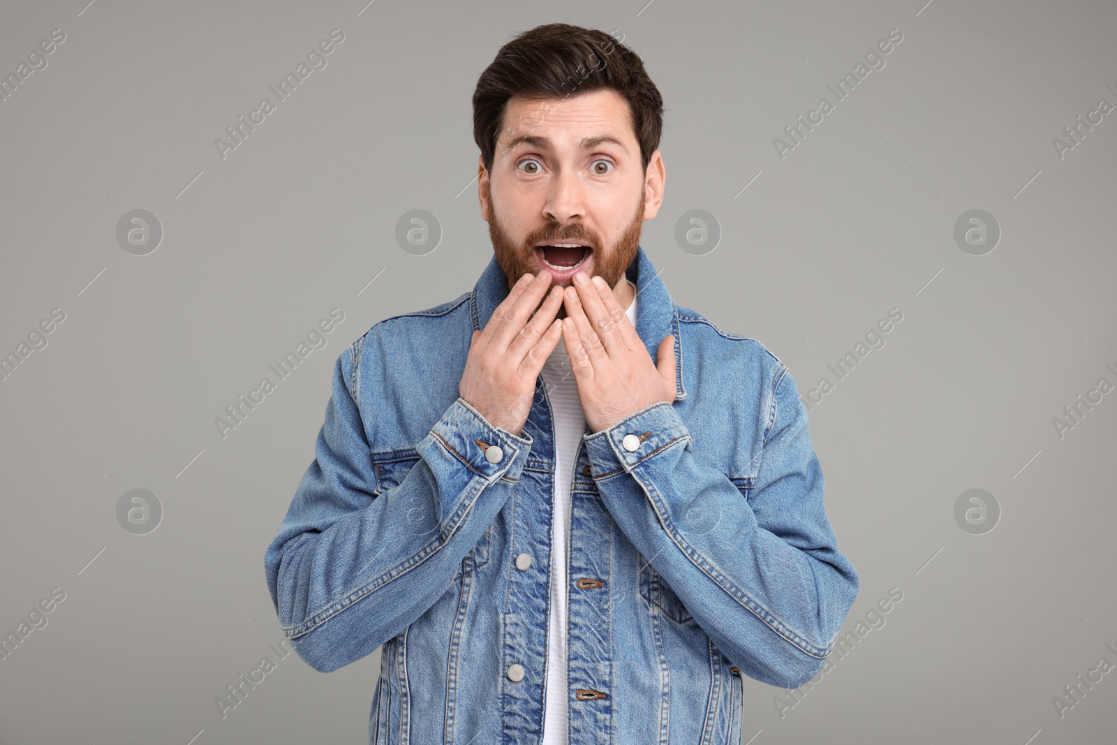 Photo of Portrait of surprised man on grey background