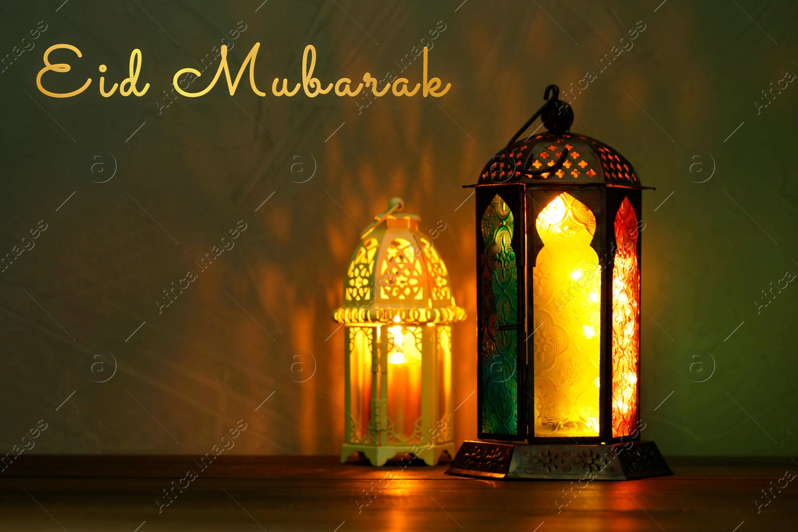 Image of Eid Mubarak greeting card. Arabic lanterns on wooden surface at night