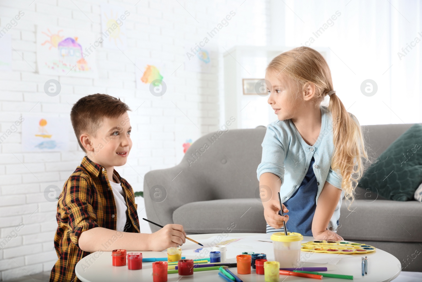 Photo of Cute little children painting together at home