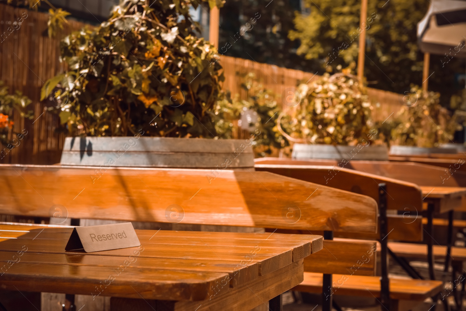 Photo of Sign Reserved on wooden table in outdoor cafe. Space for text