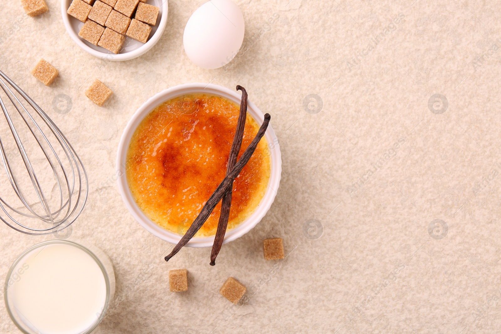 Photo of Delicious creme brulee in bowl and ingredients on light textured table, flat lay. Space for text
