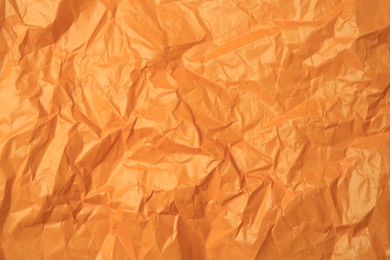 Sheet of crumpled orange paper as background, top view