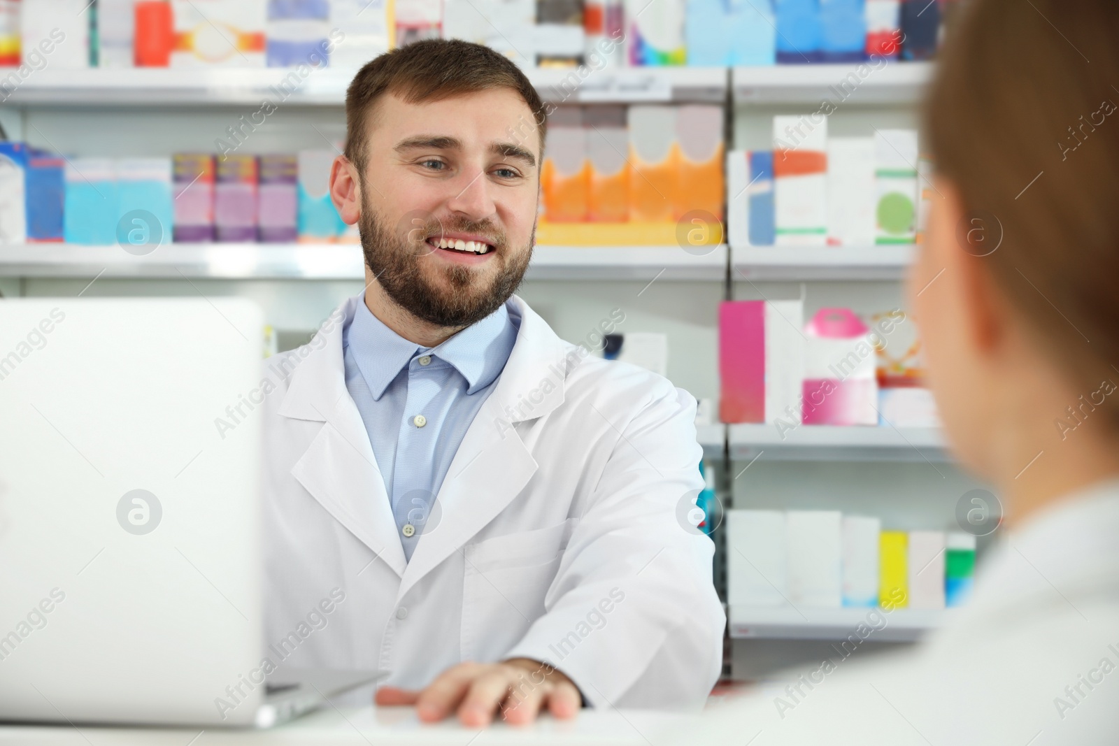 Image of Professional pharmacist working with customer in modern drugstore