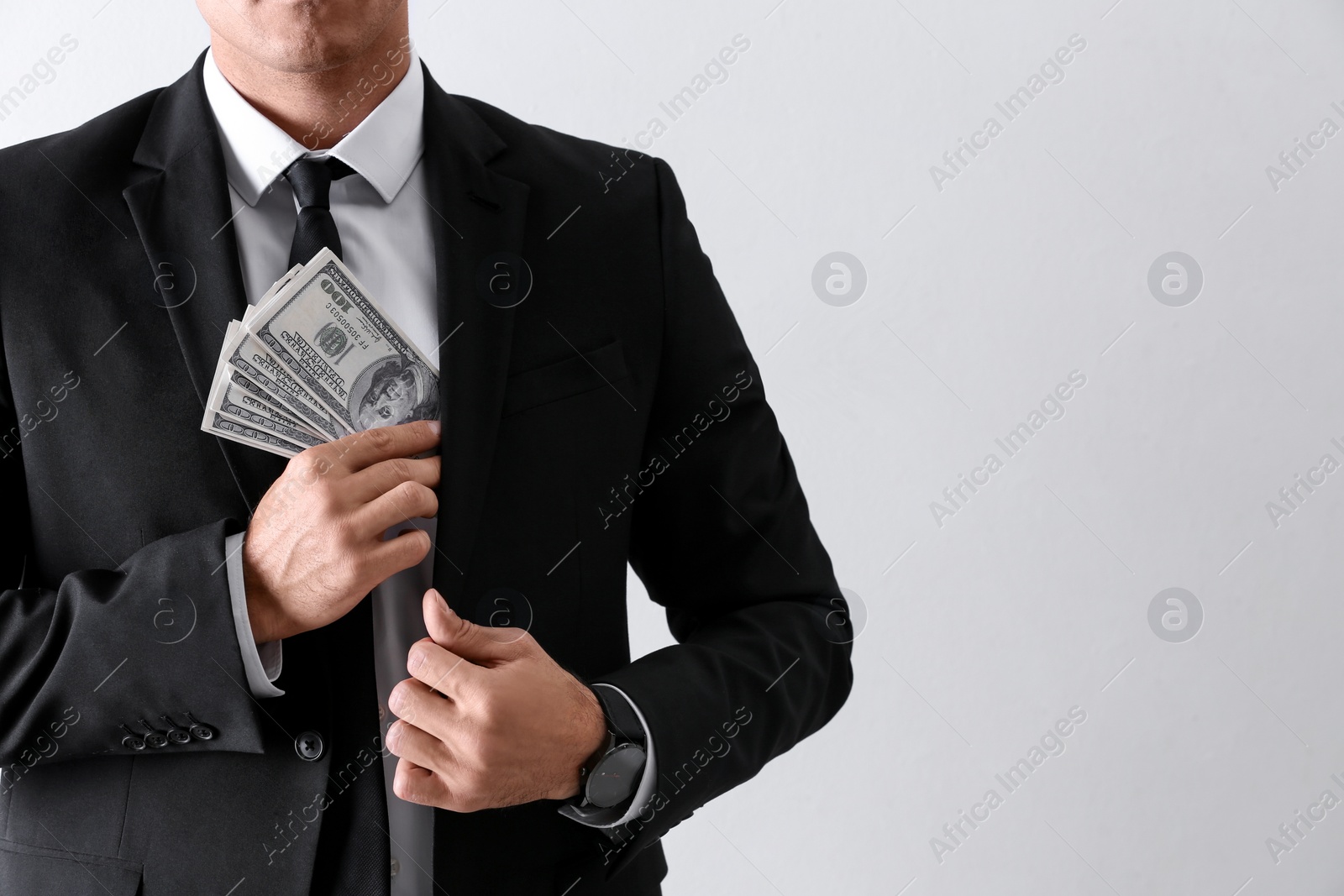 Photo of Man with bribe money on light background, closeup. Space for text