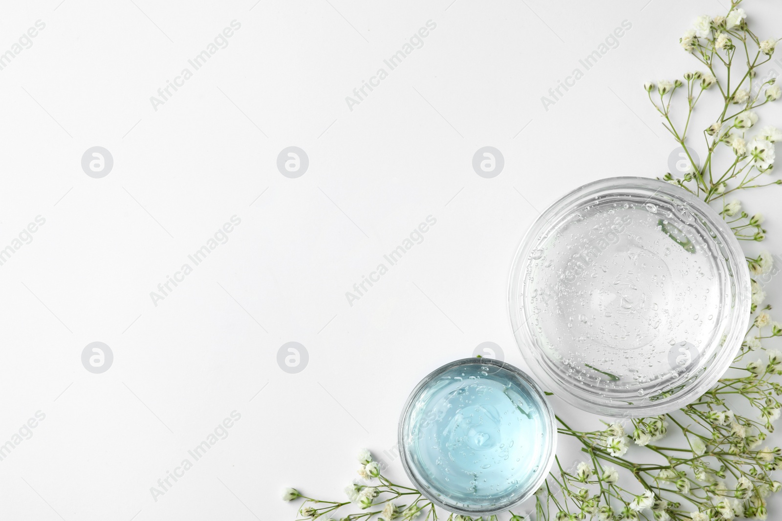 Photo of Composition with cosmetic gel and beautiful flowers on white background, top view