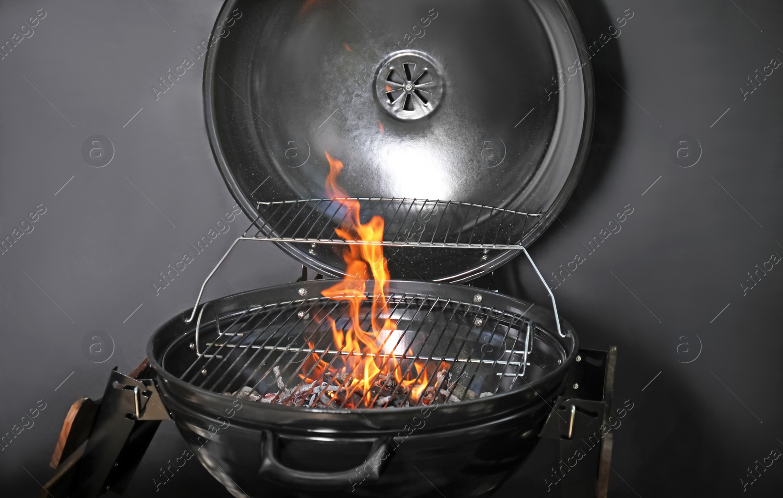 Photo of New modern barbecue grill with coals on black background