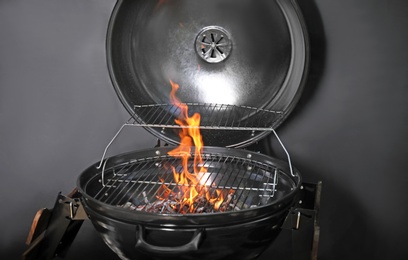 Photo of New modern barbecue grill with coals on black background