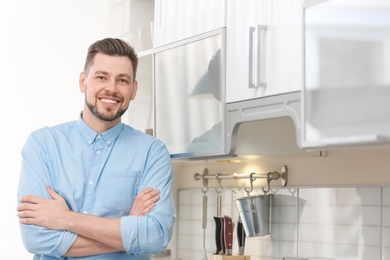 Photo of Portrait of handsome young man in kitchen