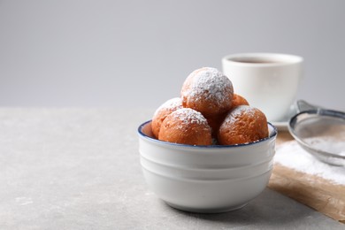 Delicious sweet buns in bowl on gray table, space for text