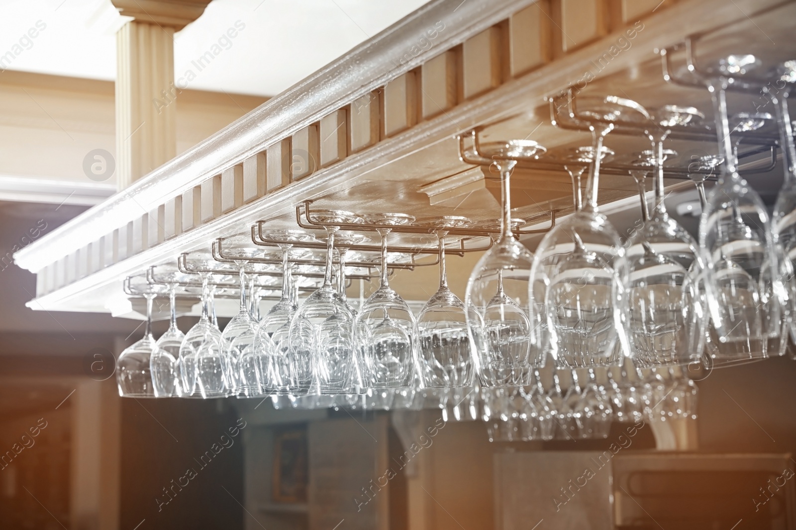 Photo of Set of empty clean glasses on bar racks