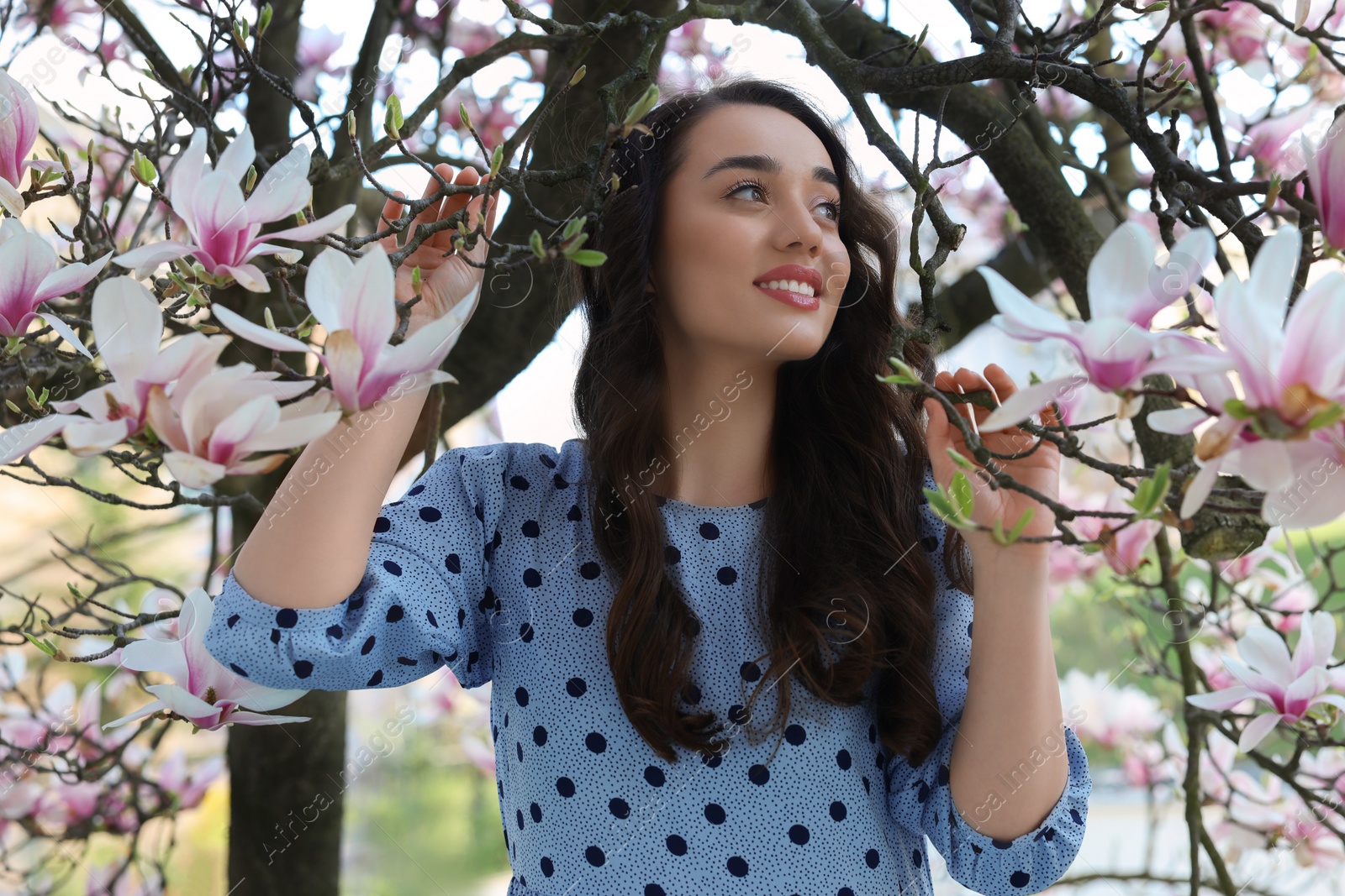 Photo of Beautiful woman near blossoming magnolia tree on spring day