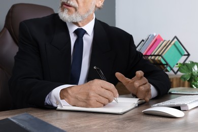 Photo of Boss working at wooden table in office, closeup