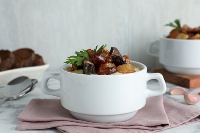 Potato puree and tasty fried cracklings on white table. Cooked pork lard