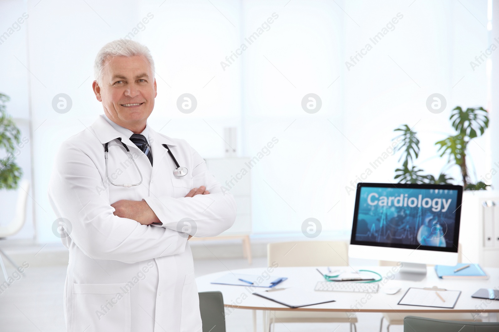 Photo of Portrait of male doctor in coat at workplace in clinic. Cardiology center