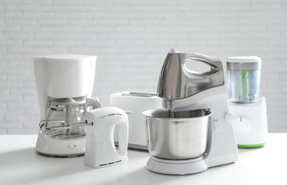 Set of modern home appliances on white table