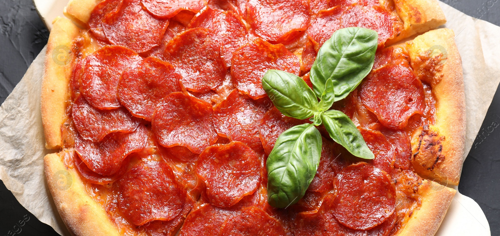 Photo of Tasty pepperoni pizza on black table, top view