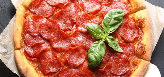 Tasty pepperoni pizza on black table, top view