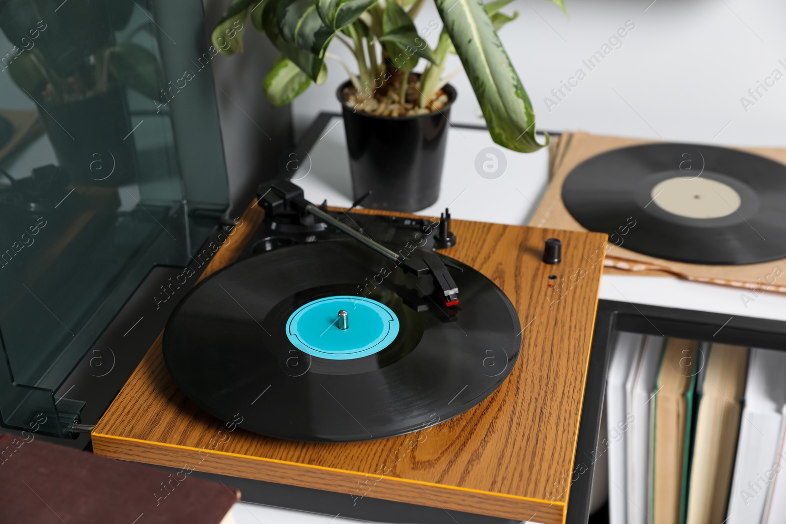 Photo of Stylish turntable with vinyl disc on table in room, closeup