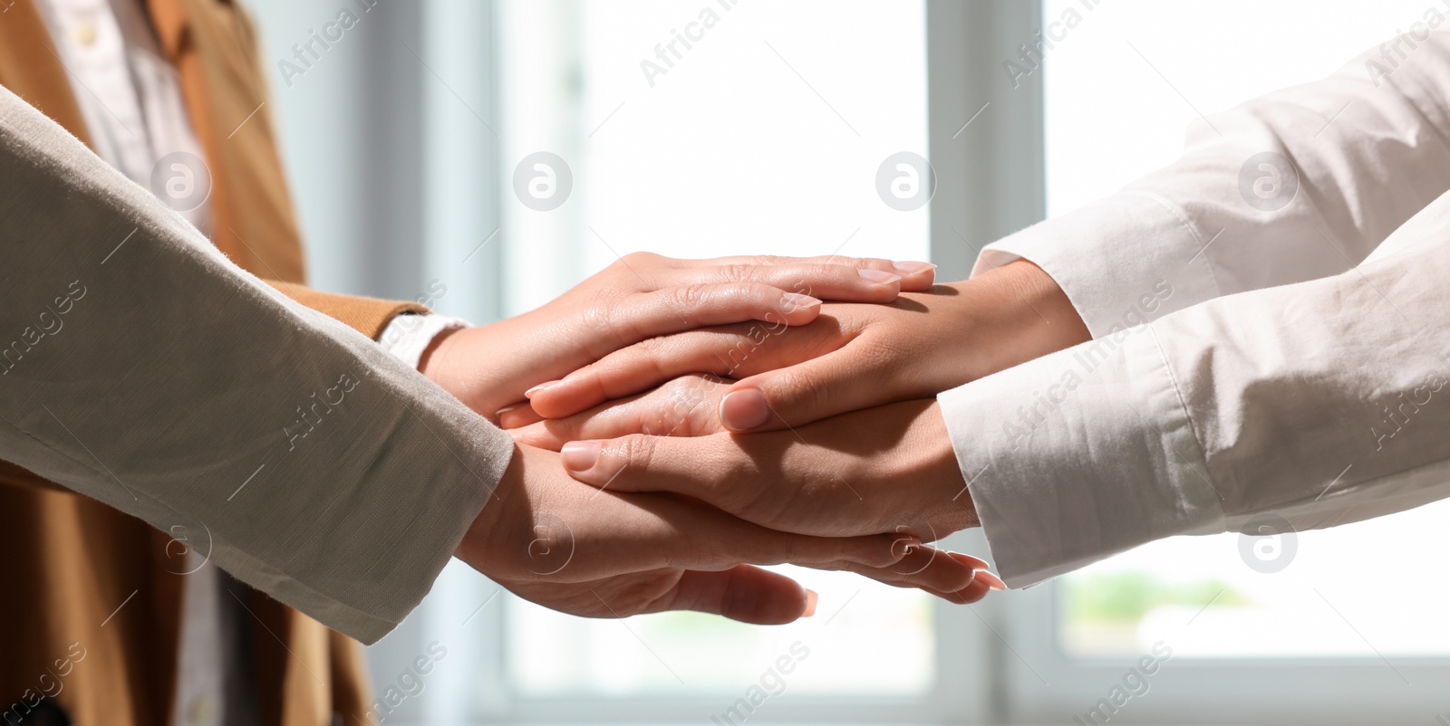 Image of Business partners. Group of people holding hands together in office, closeup. Banner design