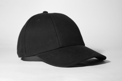 Photo of Stylish black baseball cap on white background