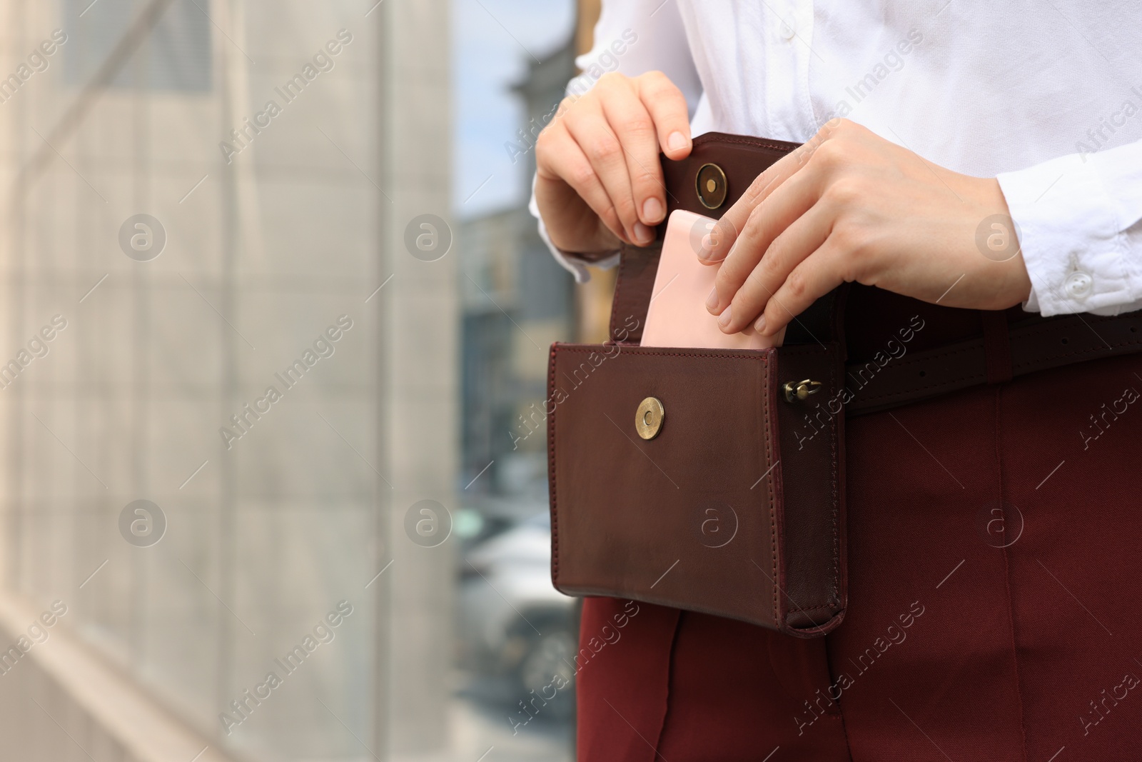 Photo of Woman taking cosmetic pocket mirror from bag outdoors, closeup. Space for text