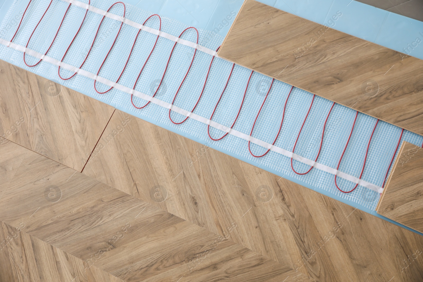 Photo of Installation of modern underfloor trace heating system indoors, top view