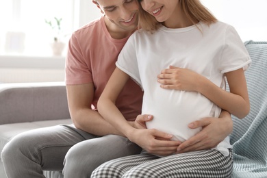 Young pregnant woman with her husband at home