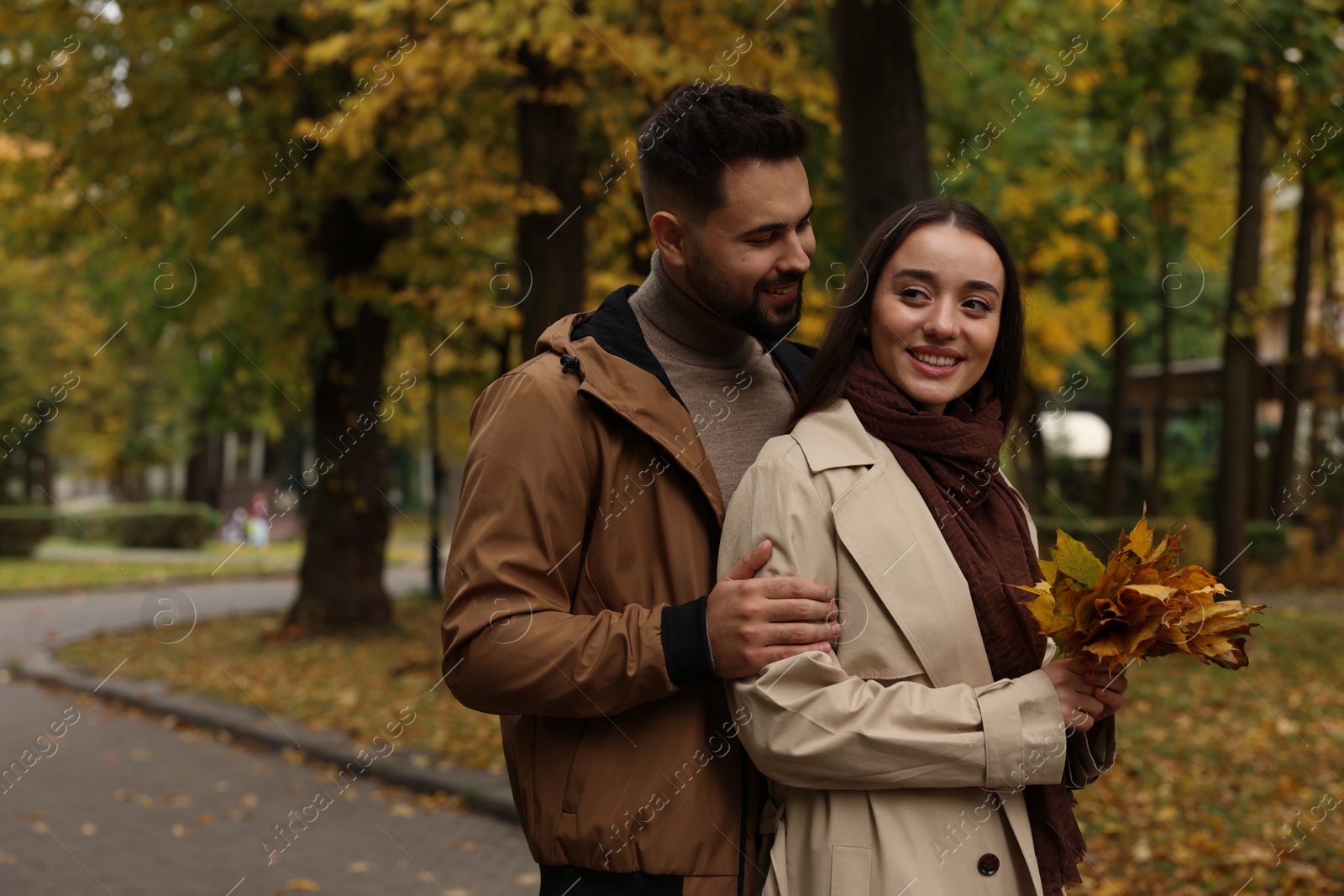 Photo of Happy young couple spending time together in autumn park