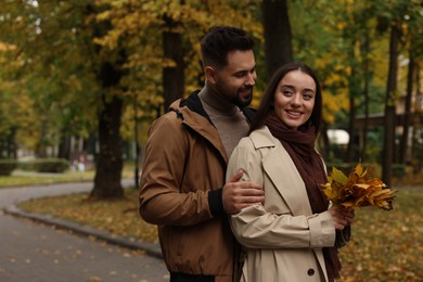 Happy young couple spending time together in autumn park