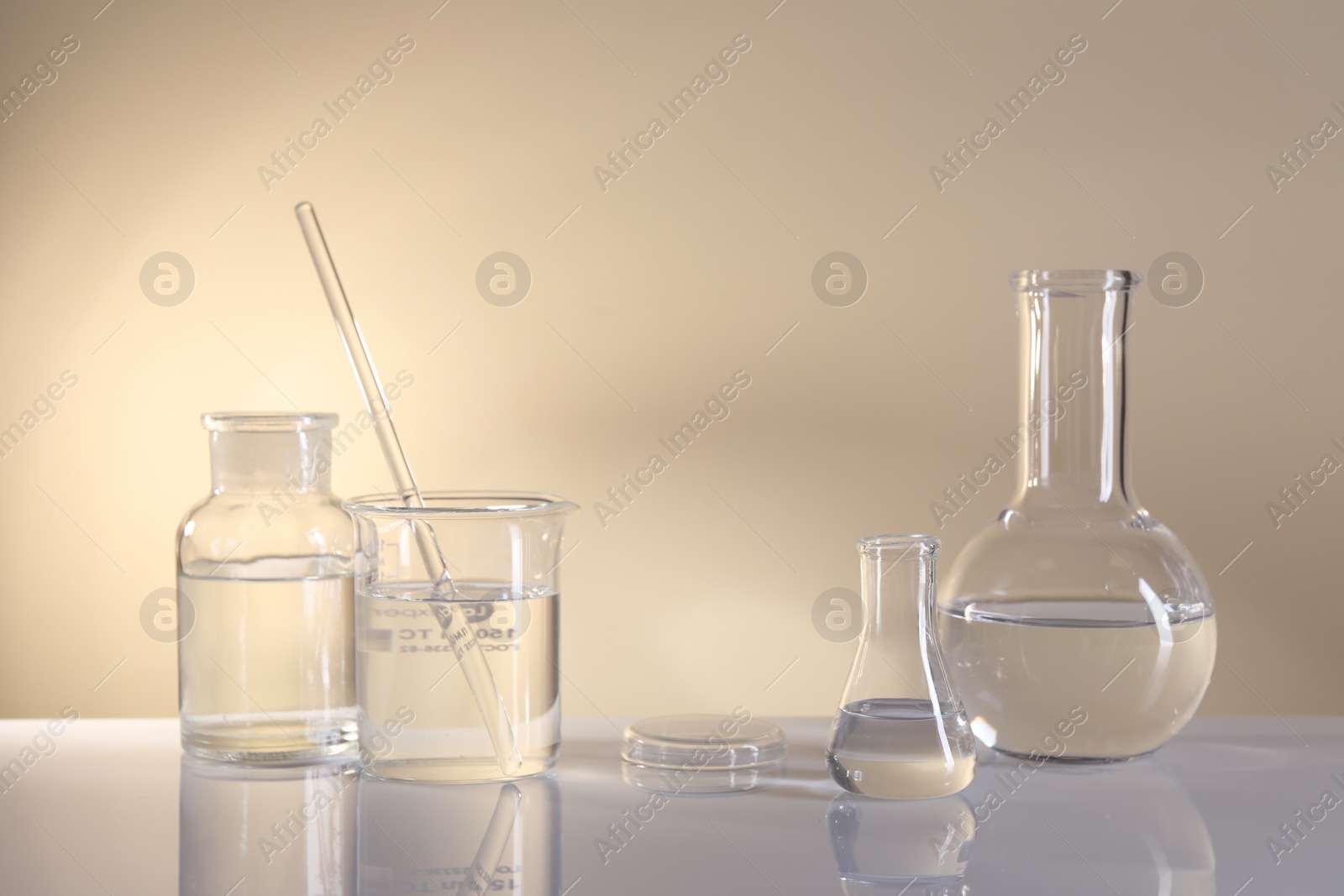 Photo of Laboratory analysis. Different glassware on table against beige background